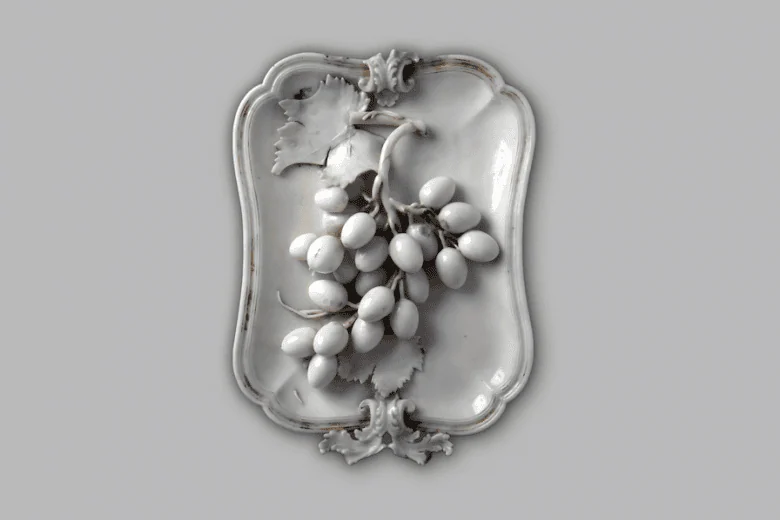 Paplāte ar reljefu vīnogu ķekaru. Neapole, Karaliskā Kapodimontes porcelāna fabrika, ap 1750. Porcelāns. Madamas pils kolekcija, Turīna, Itālija. Foto: Palazzo Madama, Museo Civico d’Arte Antica. Courtesy Fondazione Torino Musei